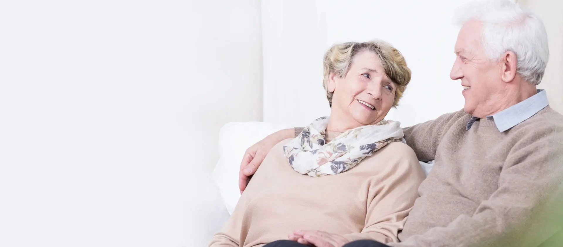 A woman sitting on the couch smiling at someone